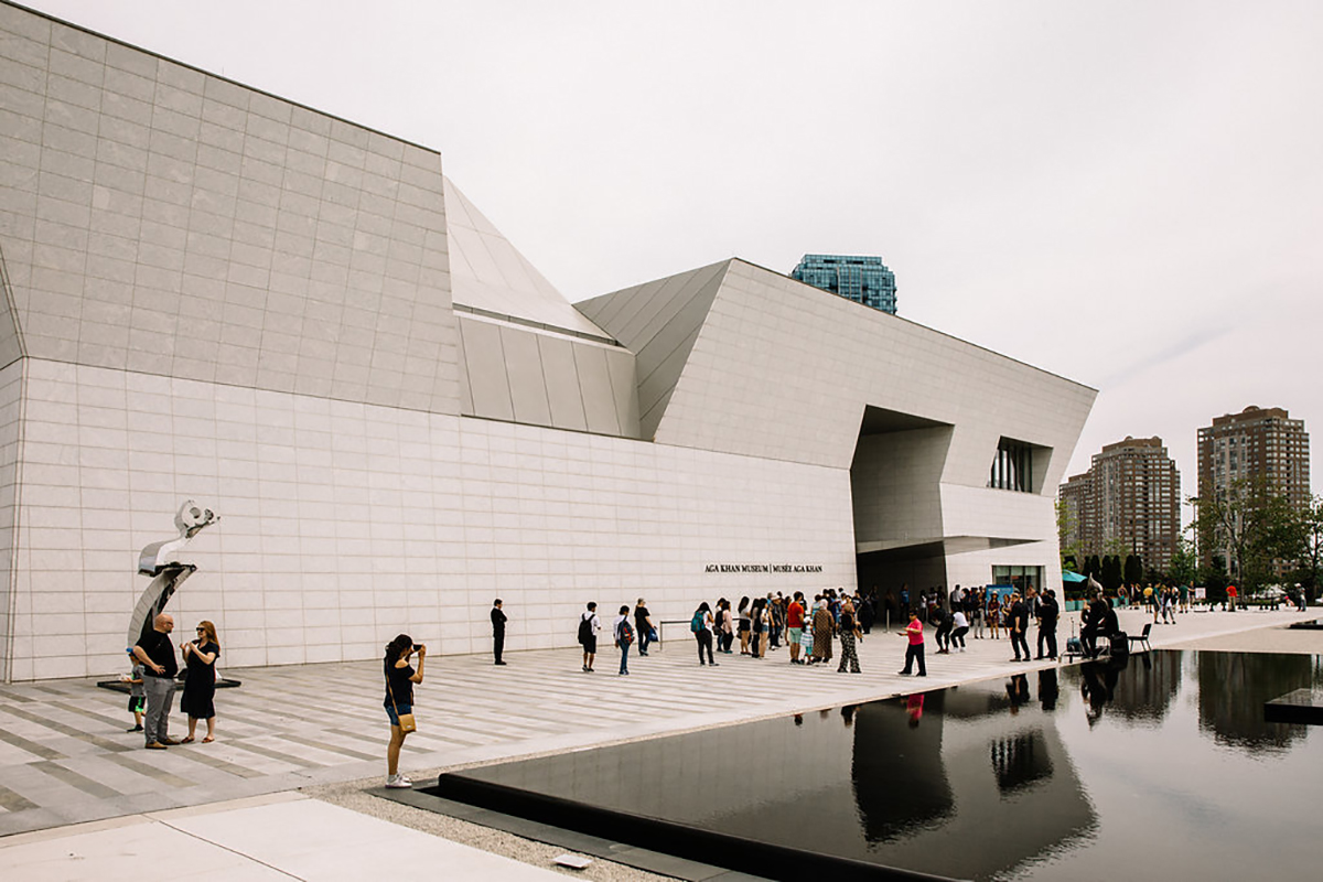 Visitors stroll outside the Museum entrance and the reflecting pools in the Park